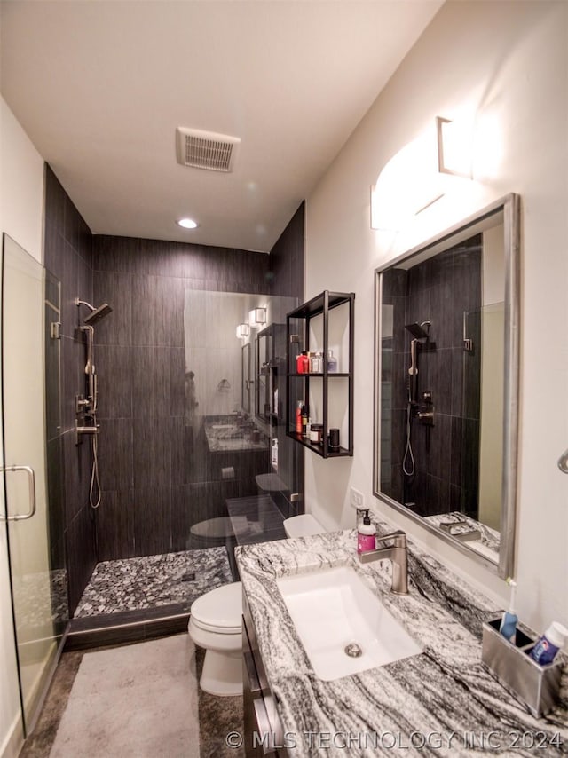 bathroom featuring a stall shower, visible vents, vanity, and toilet