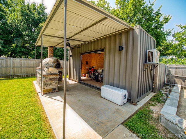 view of outdoor structure featuring a carport, a fenced backyard, and an outdoor structure