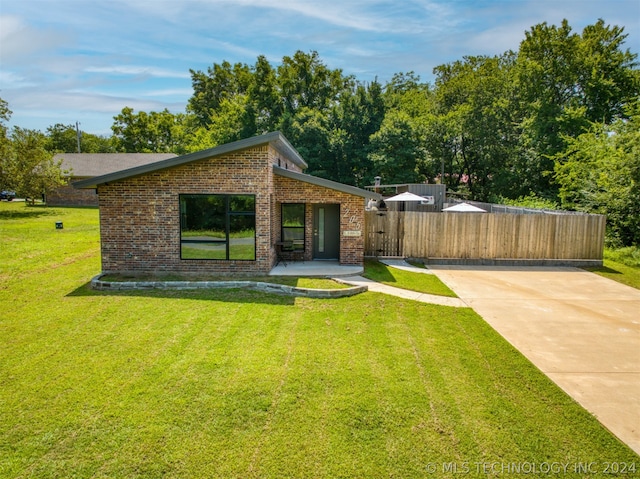 view of front of property with fence, a front lawn, and brick siding