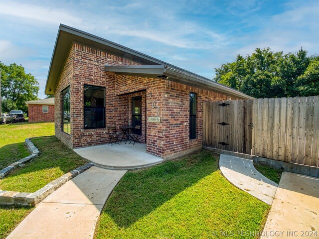 view of front of house featuring a patio and a front yard