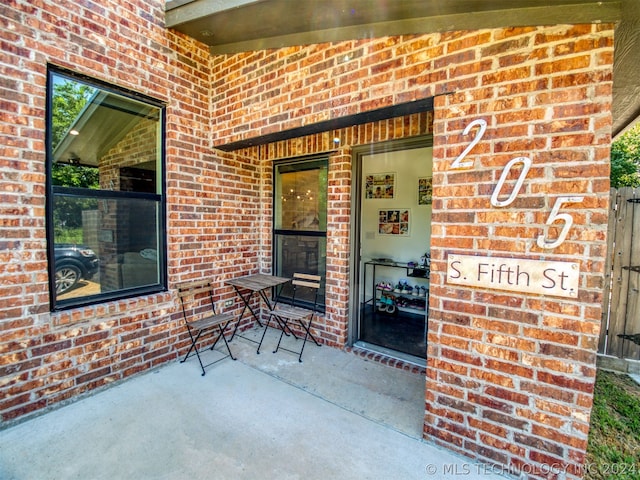 view of exterior entry with brick siding