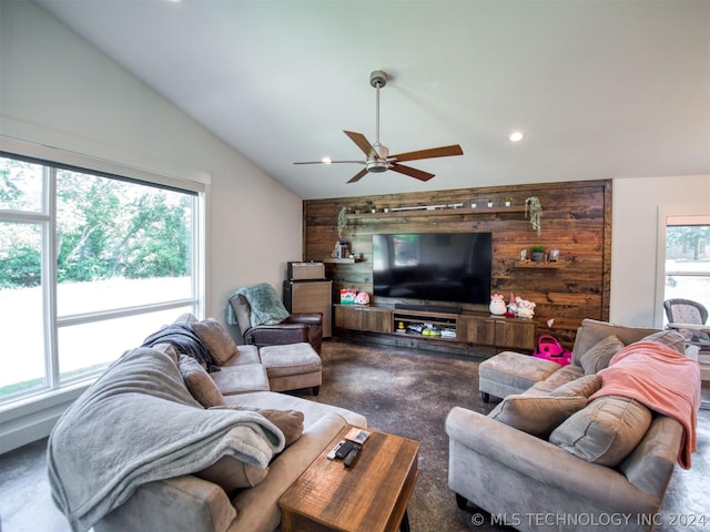 living area with recessed lighting, an accent wall, vaulted ceiling, wood walls, and concrete flooring