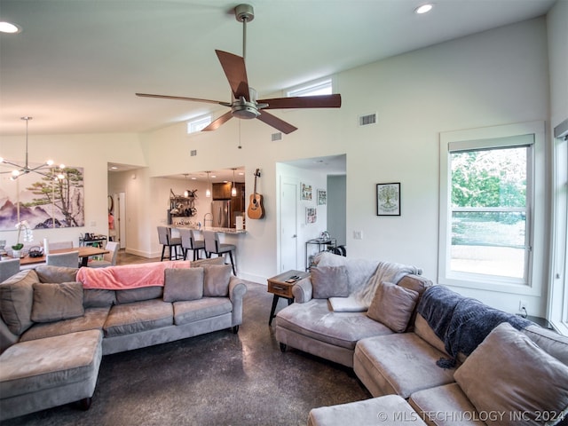 living room featuring high vaulted ceiling, recessed lighting, ceiling fan with notable chandelier, visible vents, and baseboards