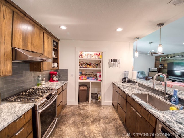 kitchen with tasteful backsplash, appliances with stainless steel finishes, light stone countertops, under cabinet range hood, and a sink