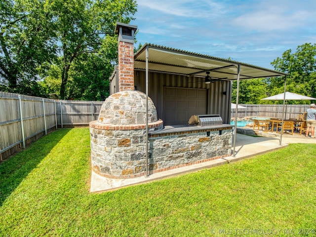 view of yard featuring a patio area, a fenced backyard, and an outdoor kitchen