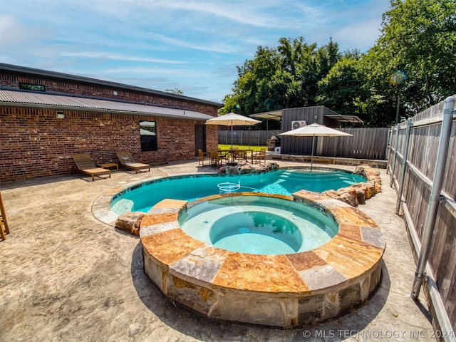 view of pool featuring a pool with connected hot tub, a patio area, and a fenced backyard