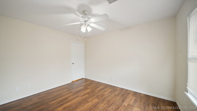 spare room with wood finished floors, baseboards, and a healthy amount of sunlight