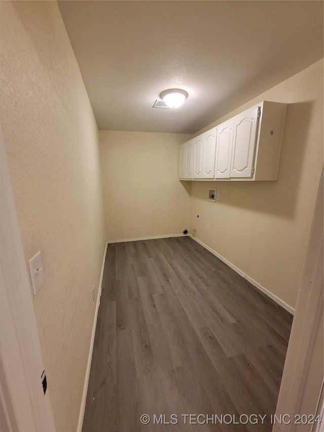 laundry area featuring dark wood finished floors, hookup for a washing machine, cabinet space, and baseboards