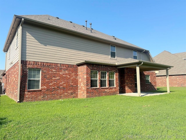 rear view of property featuring a patio area and a lawn