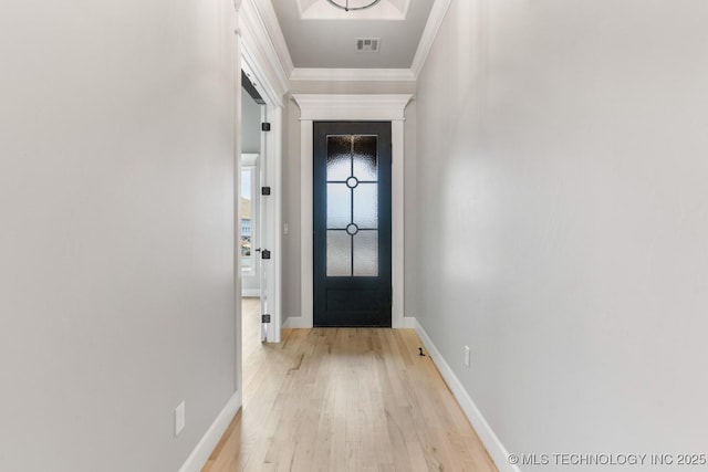 entryway with baseboards, light wood-style flooring, visible vents, and crown molding