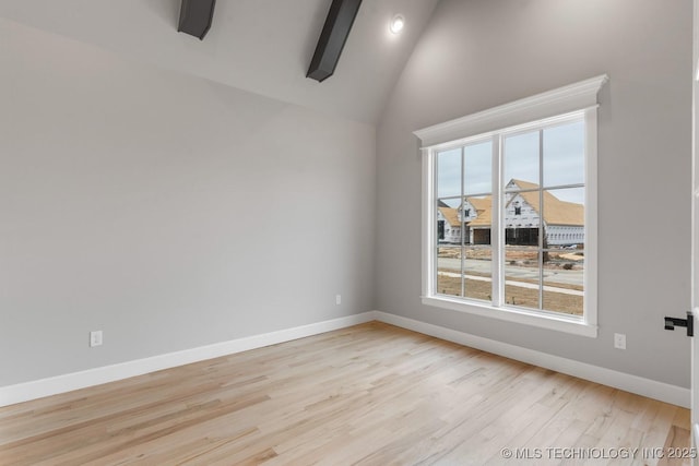 spare room with lofted ceiling, light wood finished floors, and baseboards