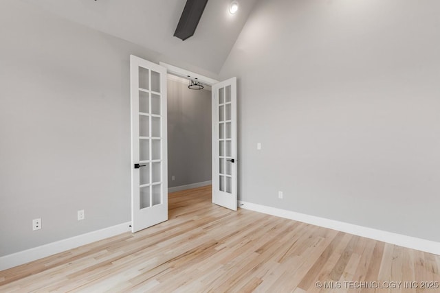 empty room with french doors, beamed ceiling, wood finished floors, and baseboards