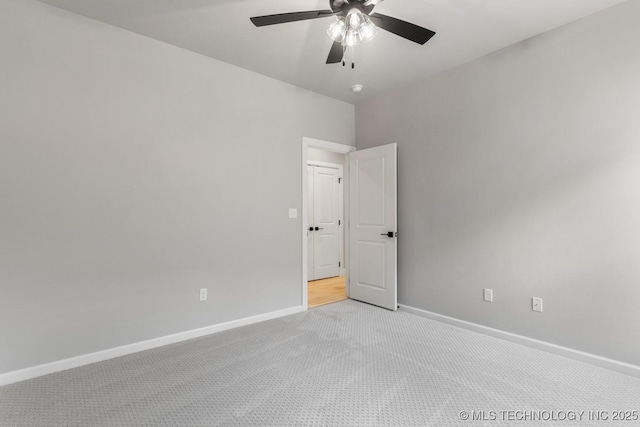 empty room with baseboards, a ceiling fan, and light colored carpet