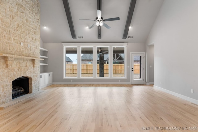 unfurnished living room with visible vents, ceiling fan, beamed ceiling, and a fireplace