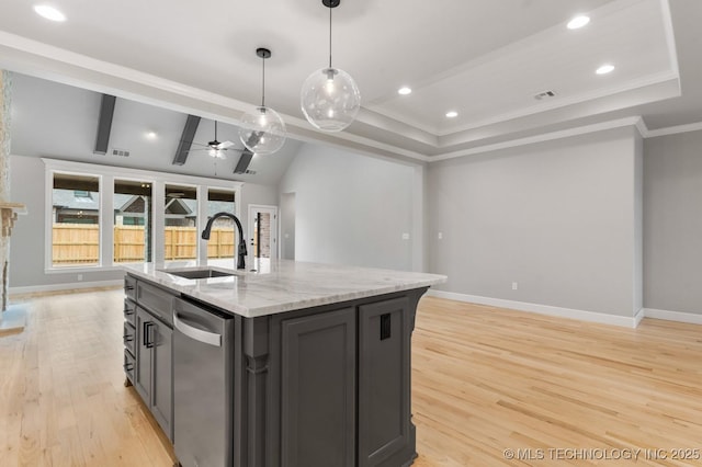 kitchen featuring ceiling fan, a sink, open floor plan, stainless steel dishwasher, and light wood finished floors