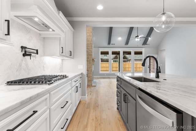 kitchen with lofted ceiling with beams, a sink, a ceiling fan, white cabinets, and appliances with stainless steel finishes