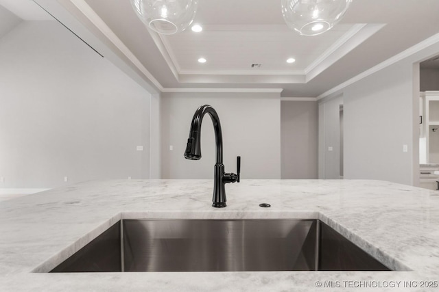 details featuring light stone counters, a tray ceiling, crown molding, a sink, and recessed lighting