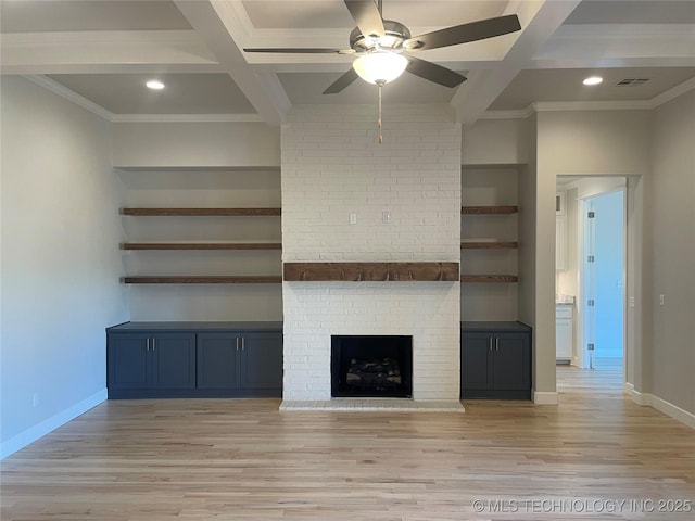 unfurnished living room with beamed ceiling, a brick fireplace, coffered ceiling, and light hardwood / wood-style floors