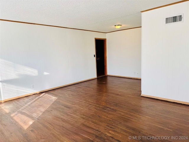 empty room featuring crown molding, dark hardwood / wood-style flooring, and a textured ceiling