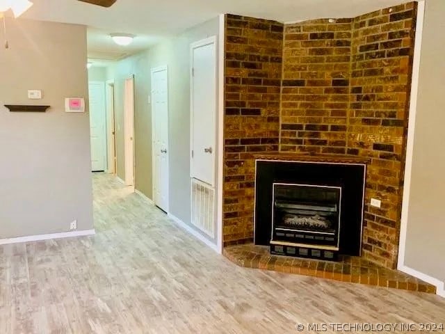 unfurnished living room featuring a fireplace and hardwood / wood-style flooring