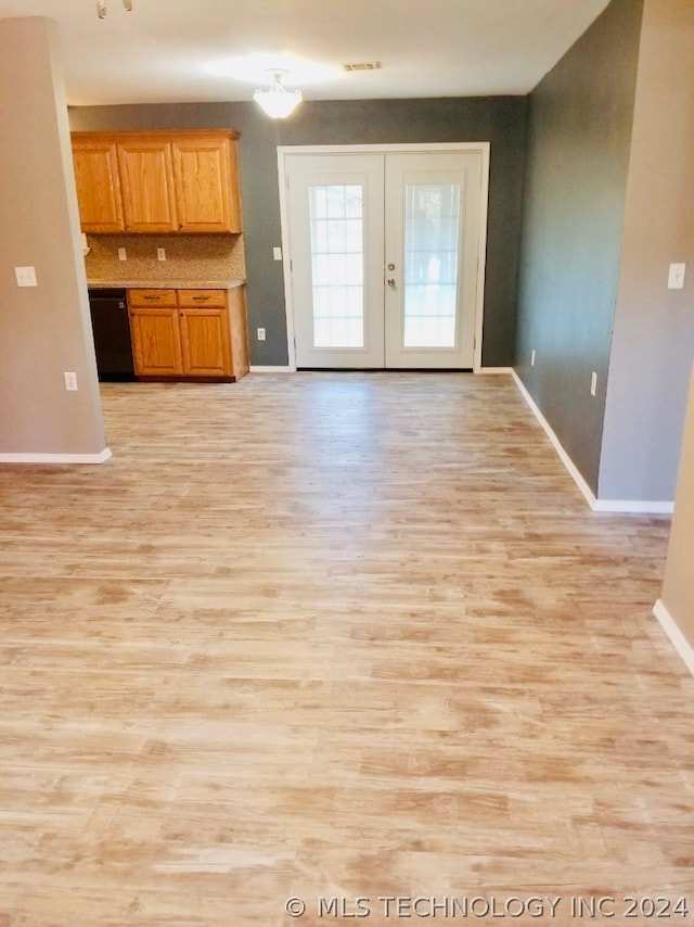 unfurnished living room featuring light wood-type flooring and french doors