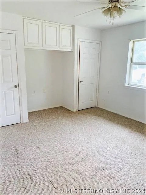 unfurnished bedroom featuring light colored carpet and ceiling fan