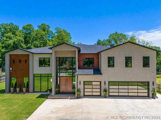 contemporary home featuring a garage and a front lawn