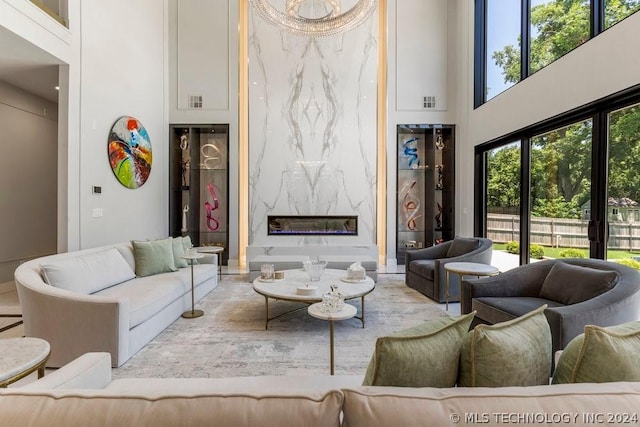 living room featuring a premium fireplace and a towering ceiling