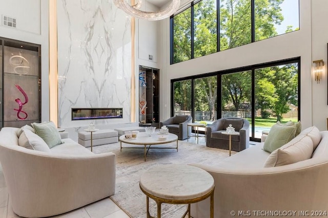 living room with a high ceiling, light tile patterned floors, and a fireplace