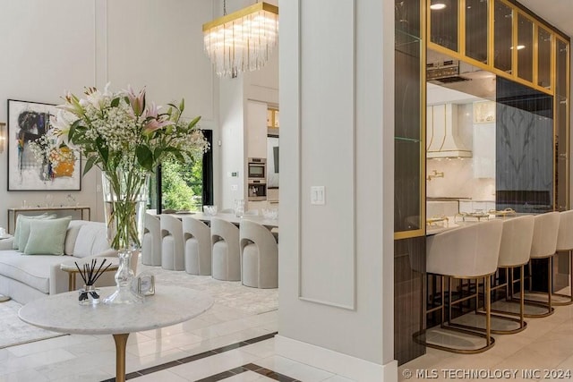 interior space with premium range hood, tile patterned flooring, and a notable chandelier