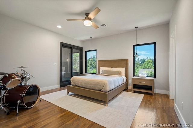 bedroom with ceiling fan, wood-type flooring, and access to outside