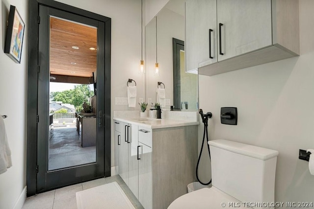 bathroom with vanity, toilet, and tile patterned flooring