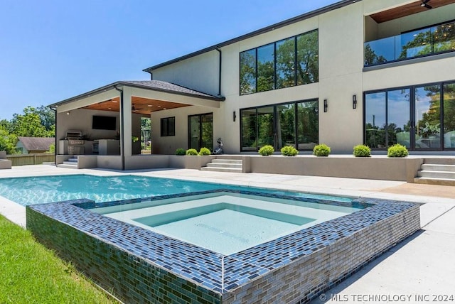 back of house featuring a patio area and exterior kitchen