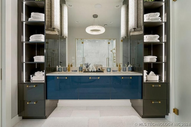 bathroom featuring tile patterned flooring, a shower with shower door, and vanity