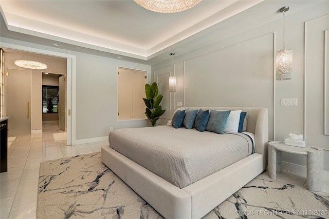 bedroom featuring light tile patterned floors and a raised ceiling