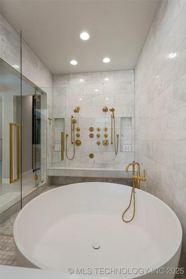 bathroom with tile walls and independent shower and bath