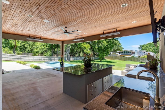 view of patio featuring sink, an outdoor kitchen, a swimming pool, and ceiling fan