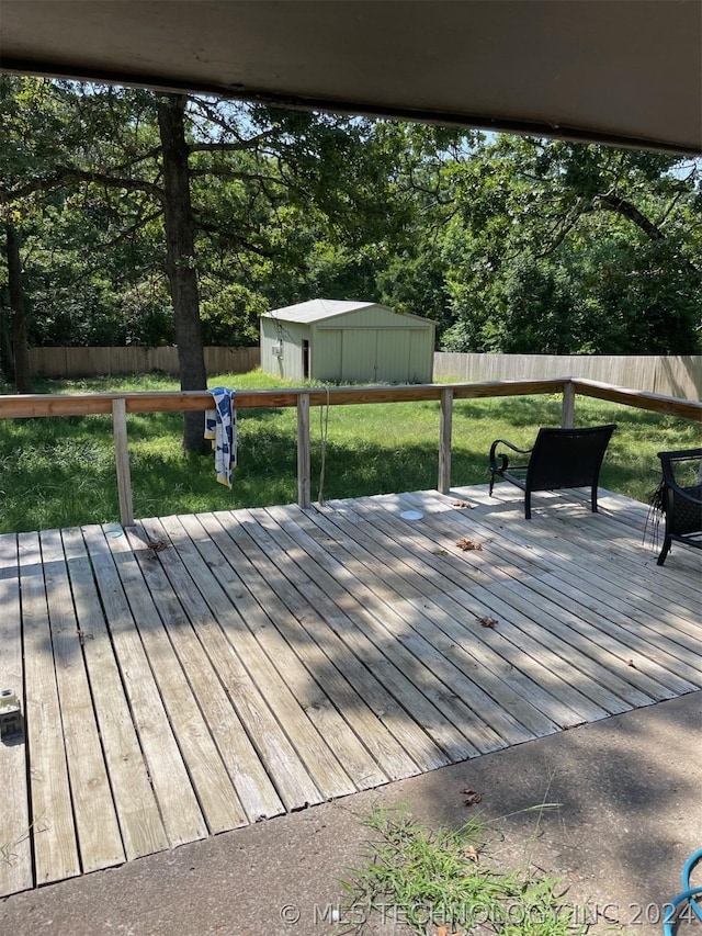 wooden deck with a yard and a storage shed