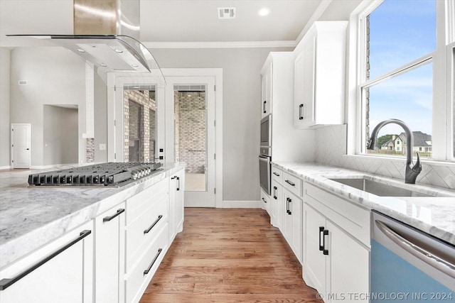 kitchen with stainless steel appliances, white cabinetry, tasteful backsplash, and light stone countertops