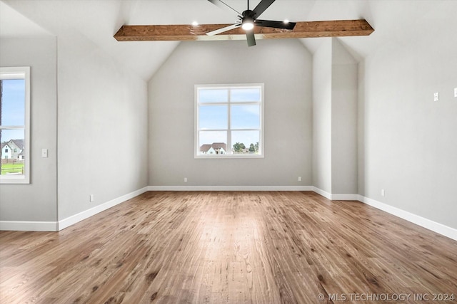 unfurnished room featuring light hardwood / wood-style flooring, lofted ceiling with beams, and plenty of natural light