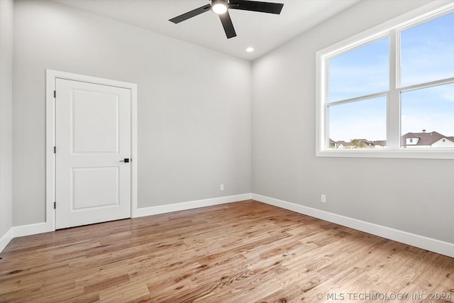 unfurnished room with ceiling fan, a wealth of natural light, and light hardwood / wood-style flooring