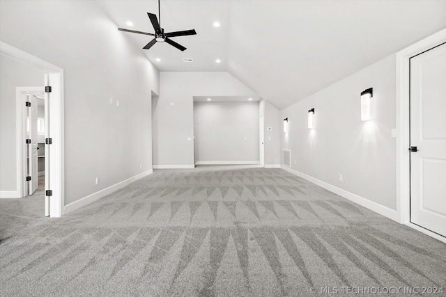 empty room with light colored carpet, ceiling fan, and vaulted ceiling