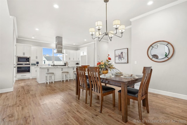 dining room featuring ornamental molding, recessed lighting, light wood-style flooring, and baseboards