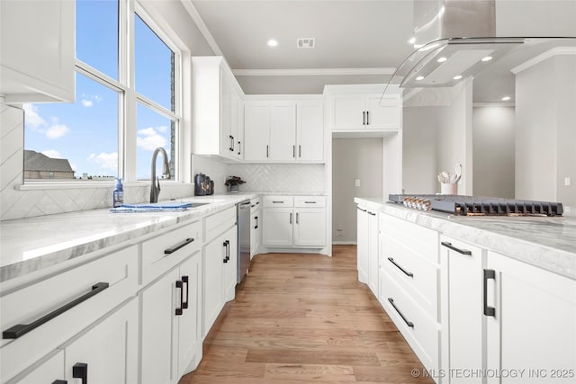 kitchen featuring white cabinets, dishwasher, light stone counters, crown molding, and a sink