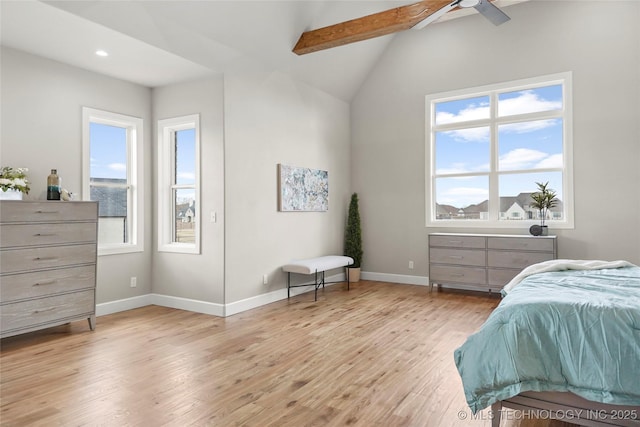 bedroom featuring baseboards, vaulted ceiling with beams, and light wood finished floors