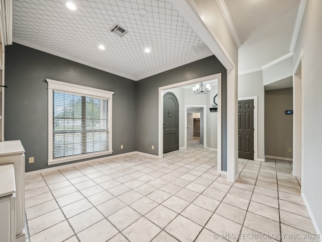 interior space with crown molding, a chandelier, and light tile patterned flooring