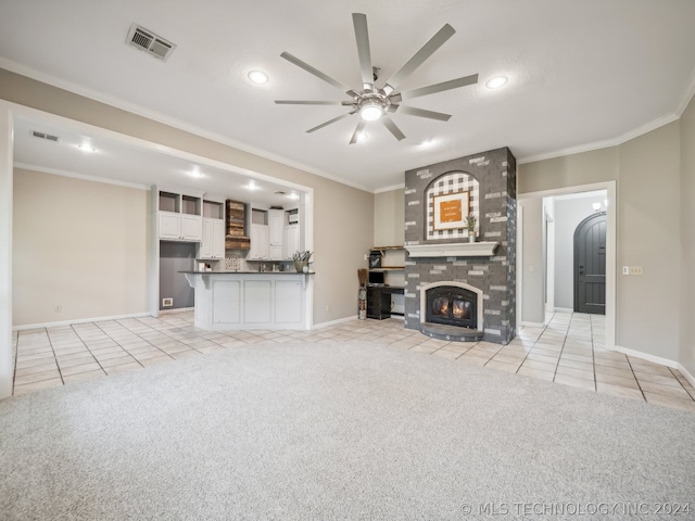 unfurnished living room featuring ceiling fan, light colored carpet, a fireplace, and crown molding