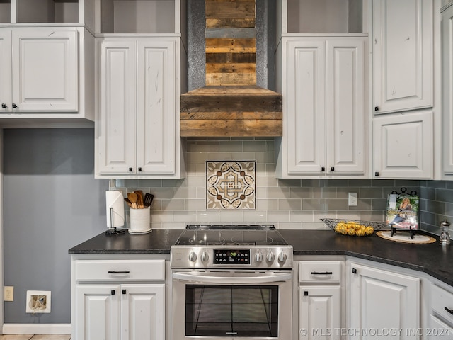 kitchen featuring electric stove, white cabinetry, wall chimney exhaust hood, and tasteful backsplash