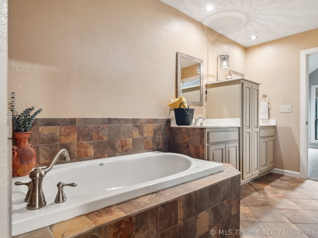 bathroom featuring tiled bath and vanity