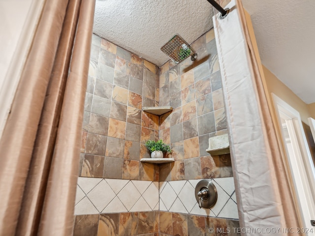 bathroom featuring a textured ceiling and a shower with curtain